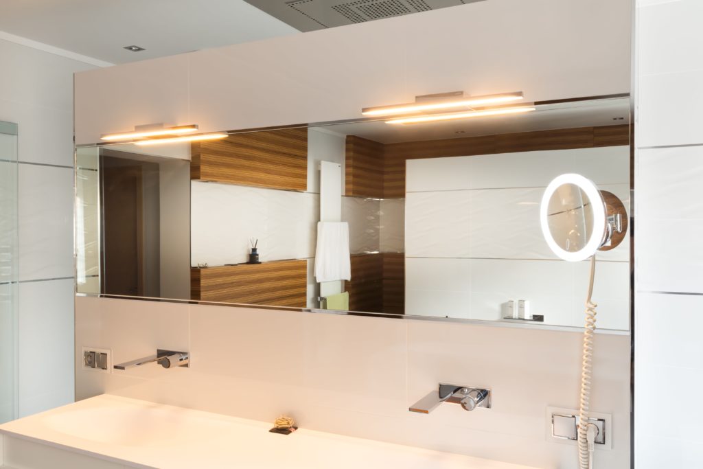 Salle de bain élégante avec grand miroir et éclairage moderne