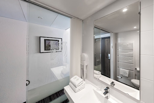 Salle de bain d’hôtel moderne avec douche vitrée et miroir