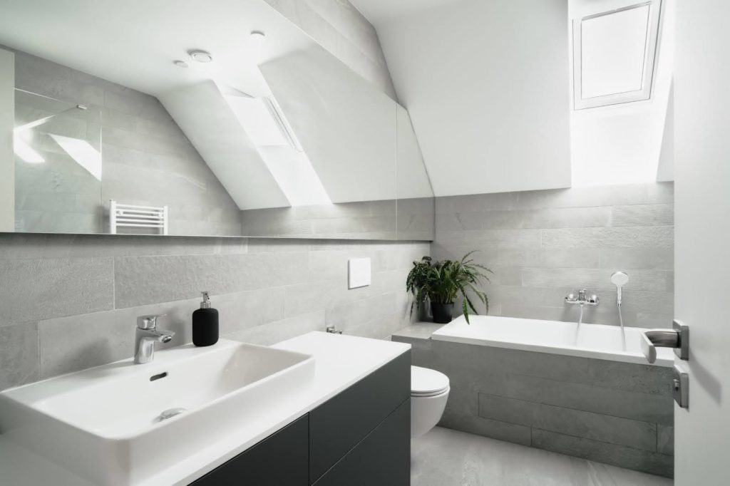 Salle de bain moderne avec baignoire, vasque et lumière naturelle